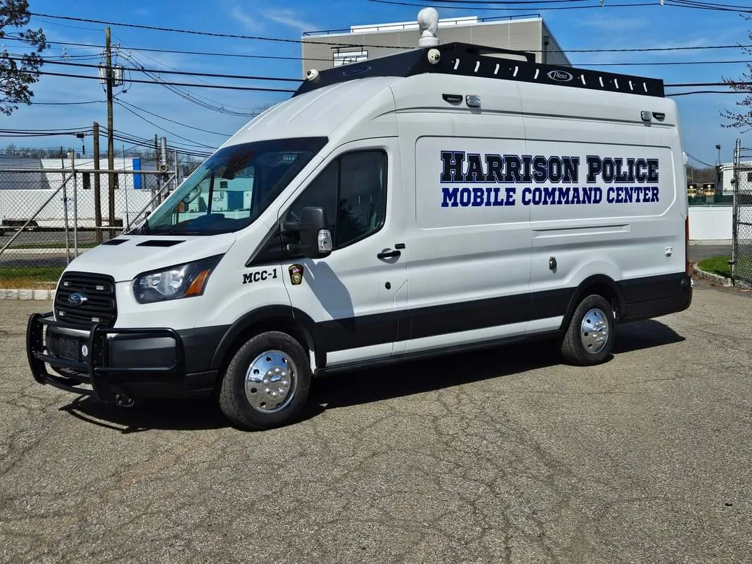 Frontline Communications CRU-22 Mobile Command vehicle parked outside in a parking lot on a sunny day.