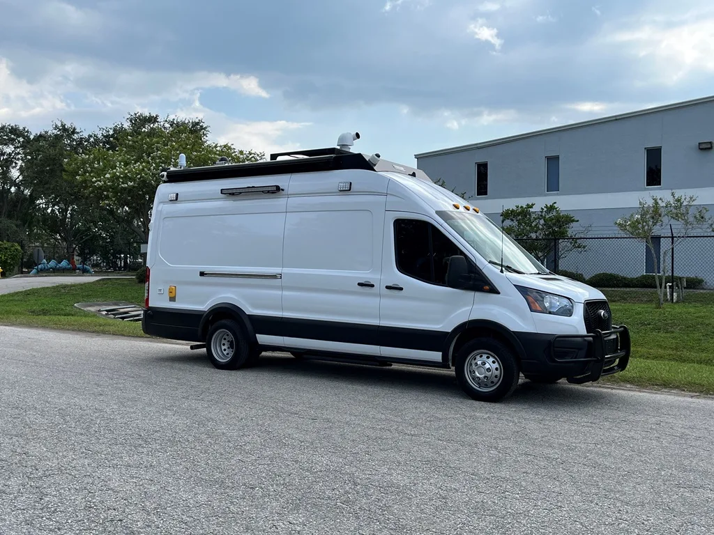 CRU-22 Mobile Command vehicle parked outside near the Frontline Communications building on a cloudy day.