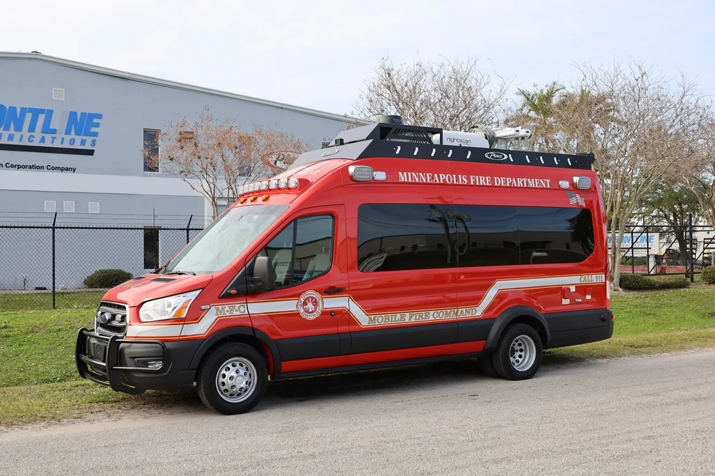 Red CRU-22 Mobile Command vehicle parked outside near the Frontline Communications building on a cloudy day.