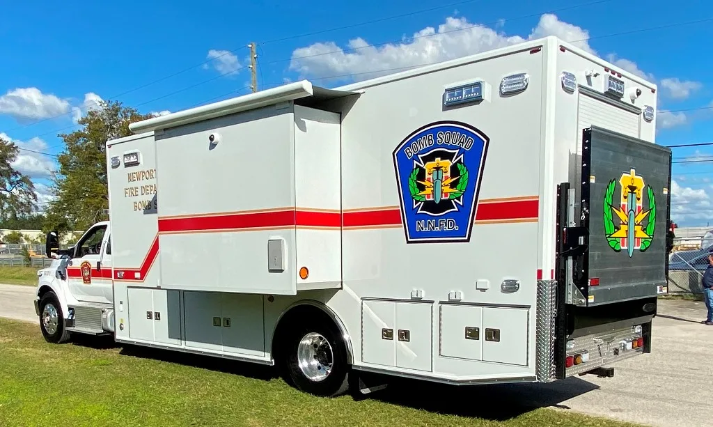 Frontline Communications C-37X EOD Bomb unit parked outside on the road on a sunny day.