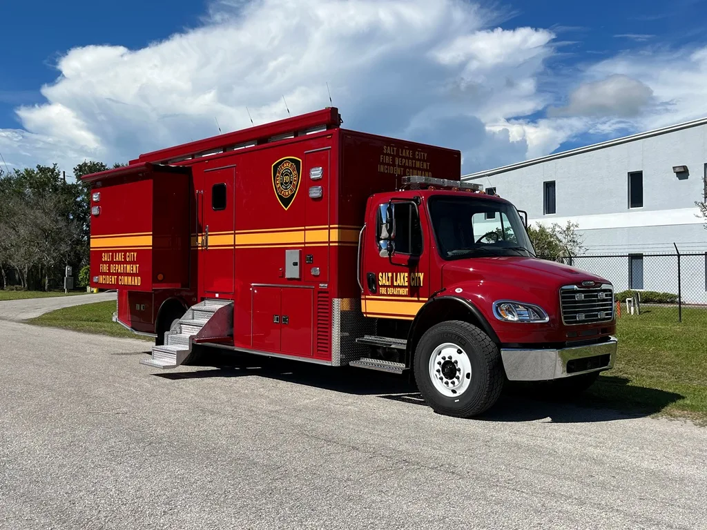 Frontline Communications red C-32X-2 Mid-Size vehicle parked outside near the building on a cloudy day.