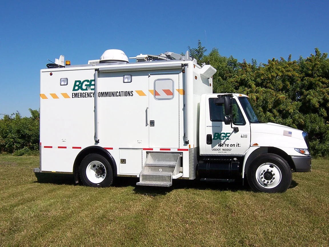 Frontline Communications Emergency Communications unit parked outside in the grass on a sunny day.