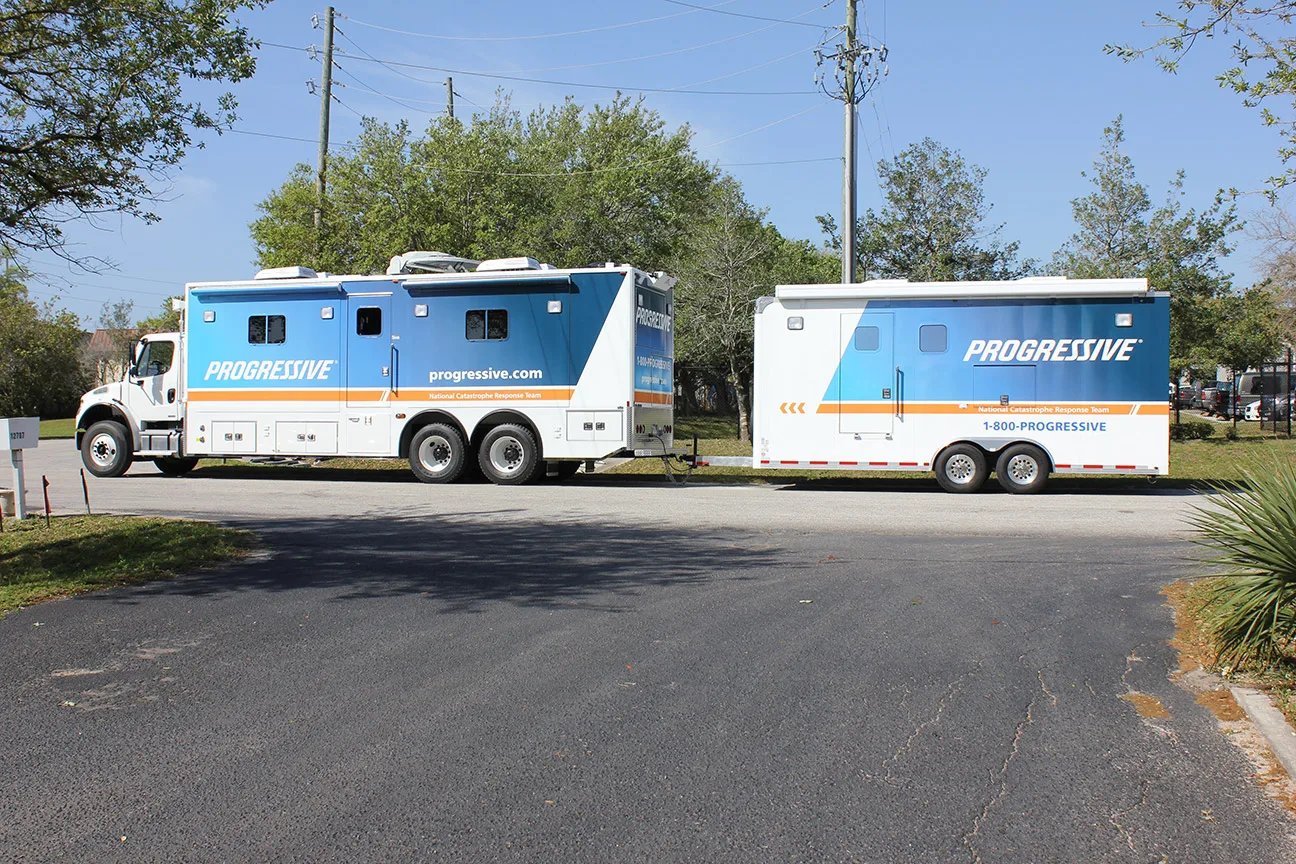 Two Frontline Communications Specialty Catastrophe Response units parked outside on a sunny day.
