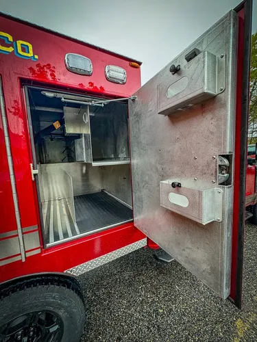 Compartment door interior with mounted outlet and handle.