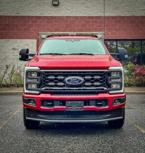 Head-on front outdoor view with grille and hood.