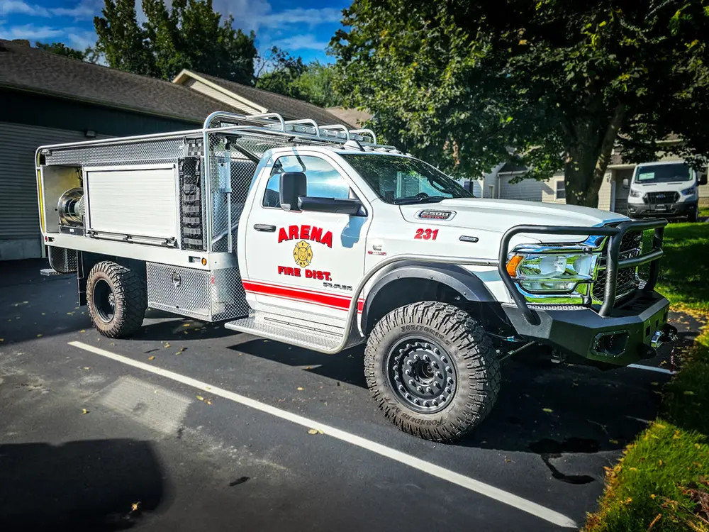 Front driver-side three-quarter view of white brush truck with utility body.