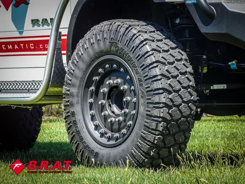 Close-up of front tire and black beadlock-style wheel.