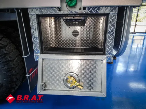 Open lower compartment with diamond-plate door and round latch.