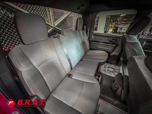 Rear bench seat area with gray upholstery and floor mat.
