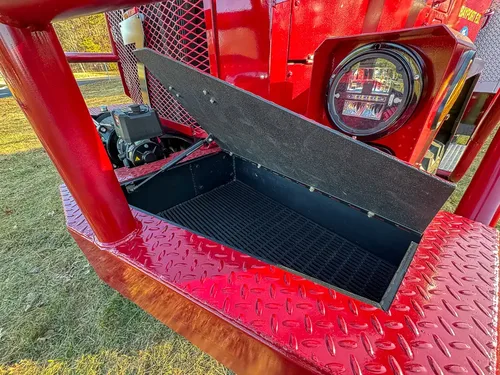 Open front step compartment from opposite side showing storage tray.