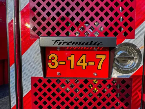 Rear panel close-up with number plate on red mesh background.
