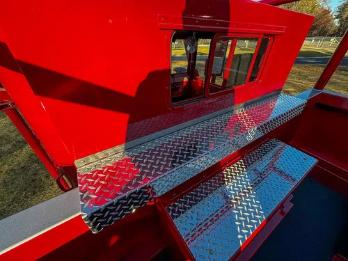 Upper side compartment closed under diamond-plate trim.