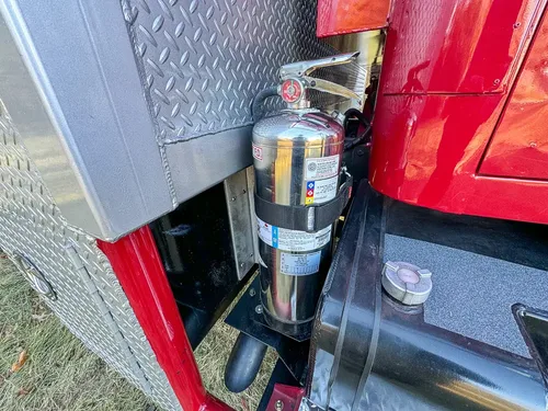 Vertical cylinder and filter assembly close-up at cab step area.