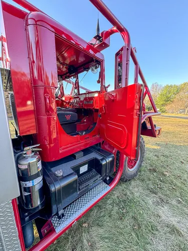 Open cab side door showing interior seating and side controls.