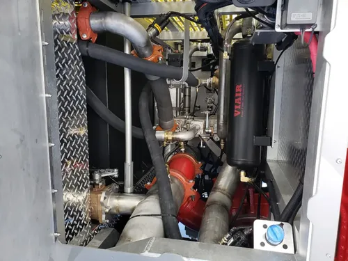 Exterior view of small fire truck showing cab, body compartments, and wheel/tire area.