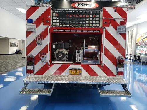 Exterior view of small fire truck showing cab, body compartments, and wheel/tire area.