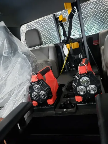 Exterior view of small fire truck showing cab, body compartments, and wheel/tire area.