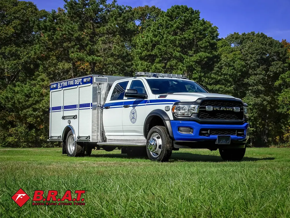 Exterior view of small fire truck showing cab, body compartments, and wheel/tire area.