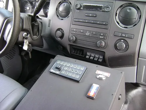 Exterior view of small fire truck showing cab, body compartments, and wheel/tire area.