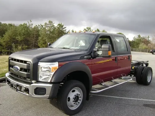 Exterior view of small fire truck showing cab, body compartments, and wheel/tire area.
