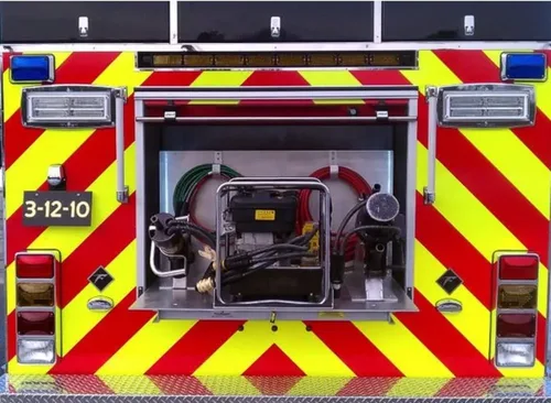 Exterior view of small fire truck showing cab, body compartments, and wheel/tire area.