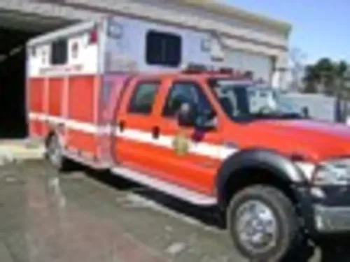 Front driver-side view of rehab unit parked outside station.