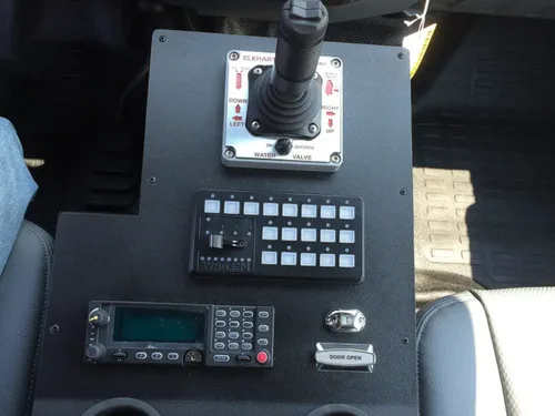 Exterior view of small fire truck showing cab, body compartments, and wheel/tire area.