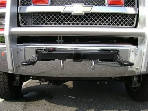 Exterior view of small fire truck showing cab, body compartments, and wheel/tire area.