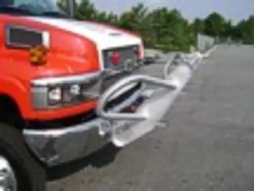 Exterior view of small fire truck showing cab, body compartments, and wheel/tire area.