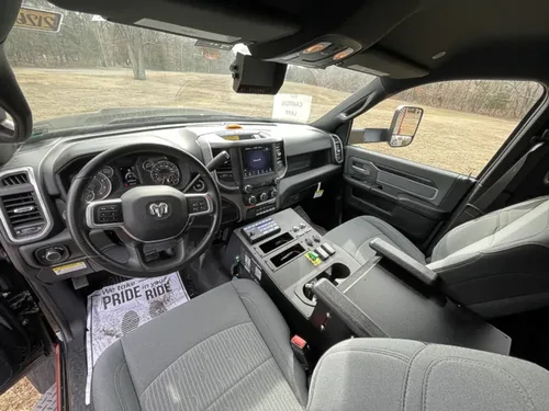 Exterior view of small fire truck showing cab, body compartments, and wheel/tire area.
