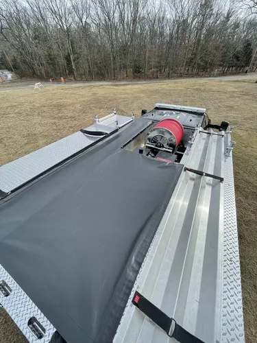 Exterior view of small fire truck showing cab, body compartments, and wheel/tire area.