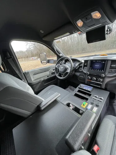 Exterior view of small fire truck showing cab, body compartments, and wheel/tire area.