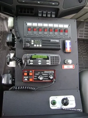 Exterior view of small fire truck showing cab, body compartments, and wheel/tire area.