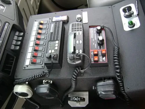 Exterior view of small fire truck showing cab, body compartments, and wheel/tire area.