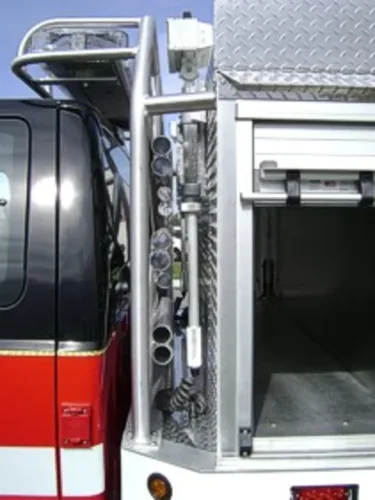 Exterior view of small fire truck showing cab, body compartments, and wheel/tire area.