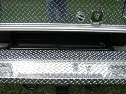 Exterior view of small fire truck showing cab, body compartments, and wheel/tire area.