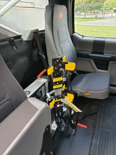 Exterior view of small fire truck showing cab, body compartments, and wheel/tire area.