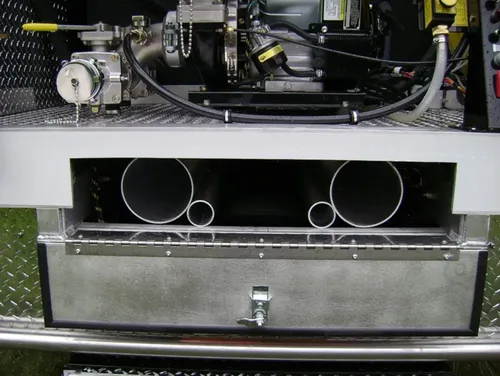 Exterior view of small fire truck showing cab, body compartments, and wheel/tire area.