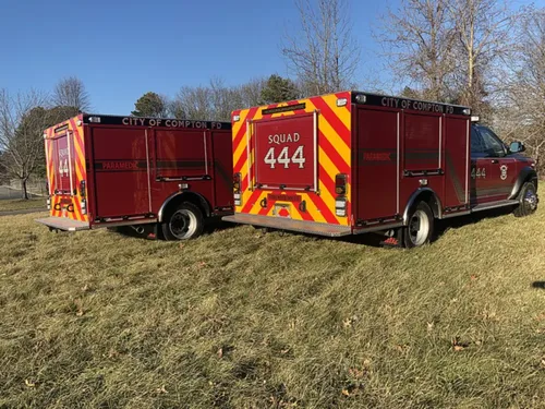 Exterior view of small fire truck showing cab, body compartments, and wheel/tire area.