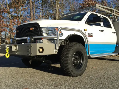 Exterior view of small fire truck showing cab, body compartments, and wheel/tire area.