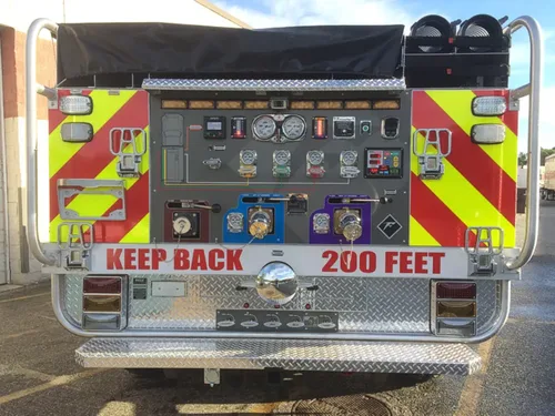 Exterior view of small fire truck showing cab, body compartments, and wheel/tire area.