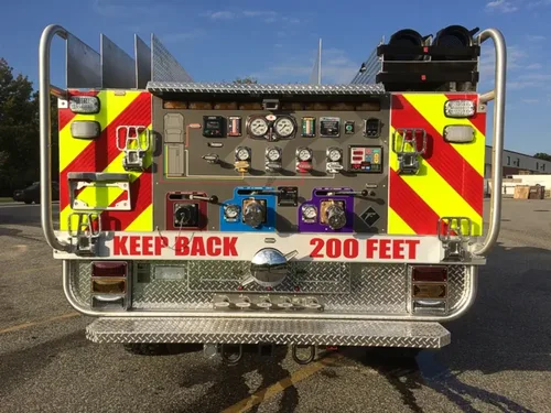 Exterior view of small fire truck showing cab, body compartments, and wheel/tire area.