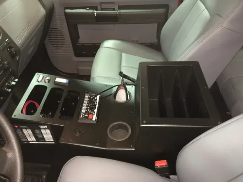 Exterior view of small fire truck showing cab, body compartments, and wheel/tire area.