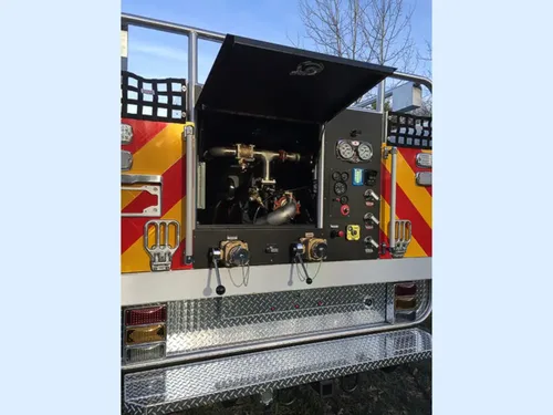 Exterior view of small fire truck showing cab, body compartments, and wheel/tire area.