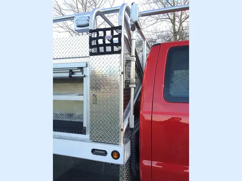 Exterior view of small fire truck showing cab, body compartments, and wheel/tire area.