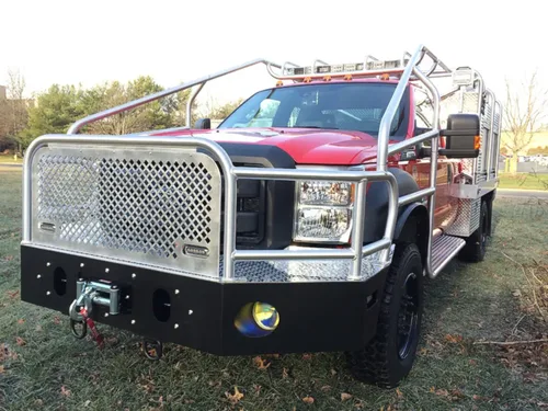 Exterior view of small fire truck showing cab, body compartments, and wheel/tire area.
