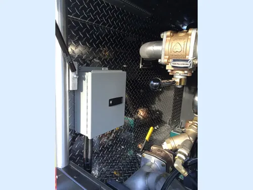 Exterior view of small fire truck showing cab, body compartments, and wheel/tire area.