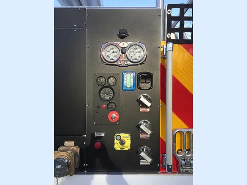 Exterior view of small fire truck showing cab, body compartments, and wheel/tire area.