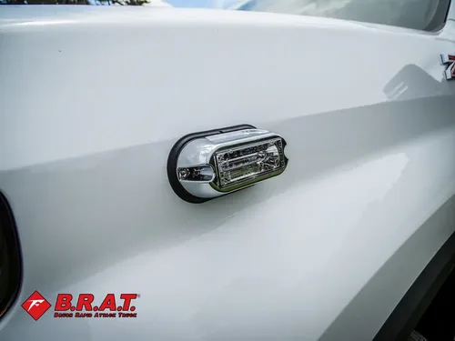 Side marker light close-up on white body panel.
