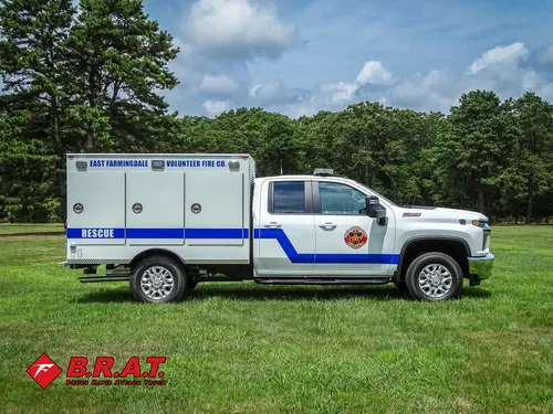 Driver-side profile of rescue truck parked on grass.